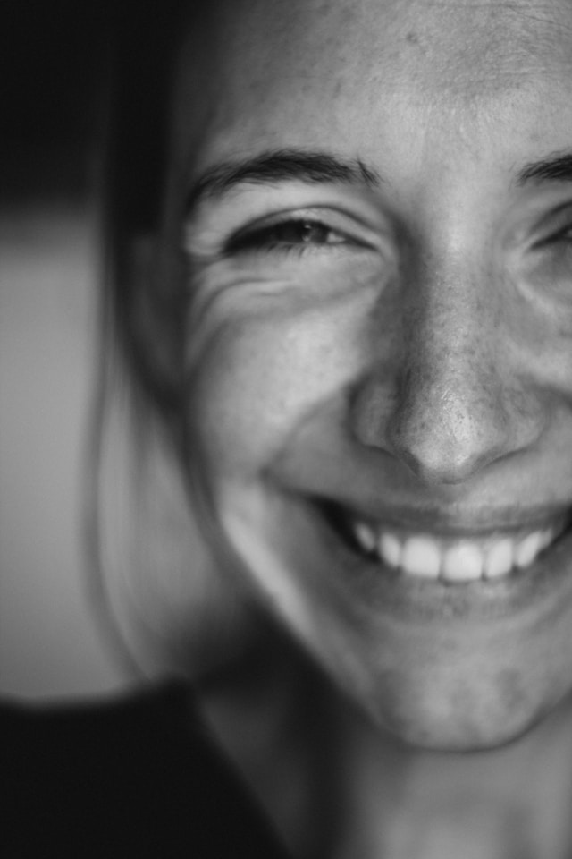 Kvinne med bredt smil, svart-hvitt portrett